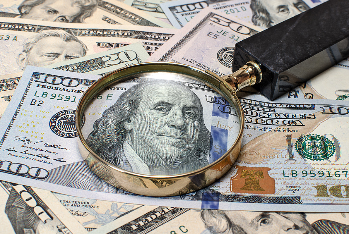 magnifying glass on dollar bills
