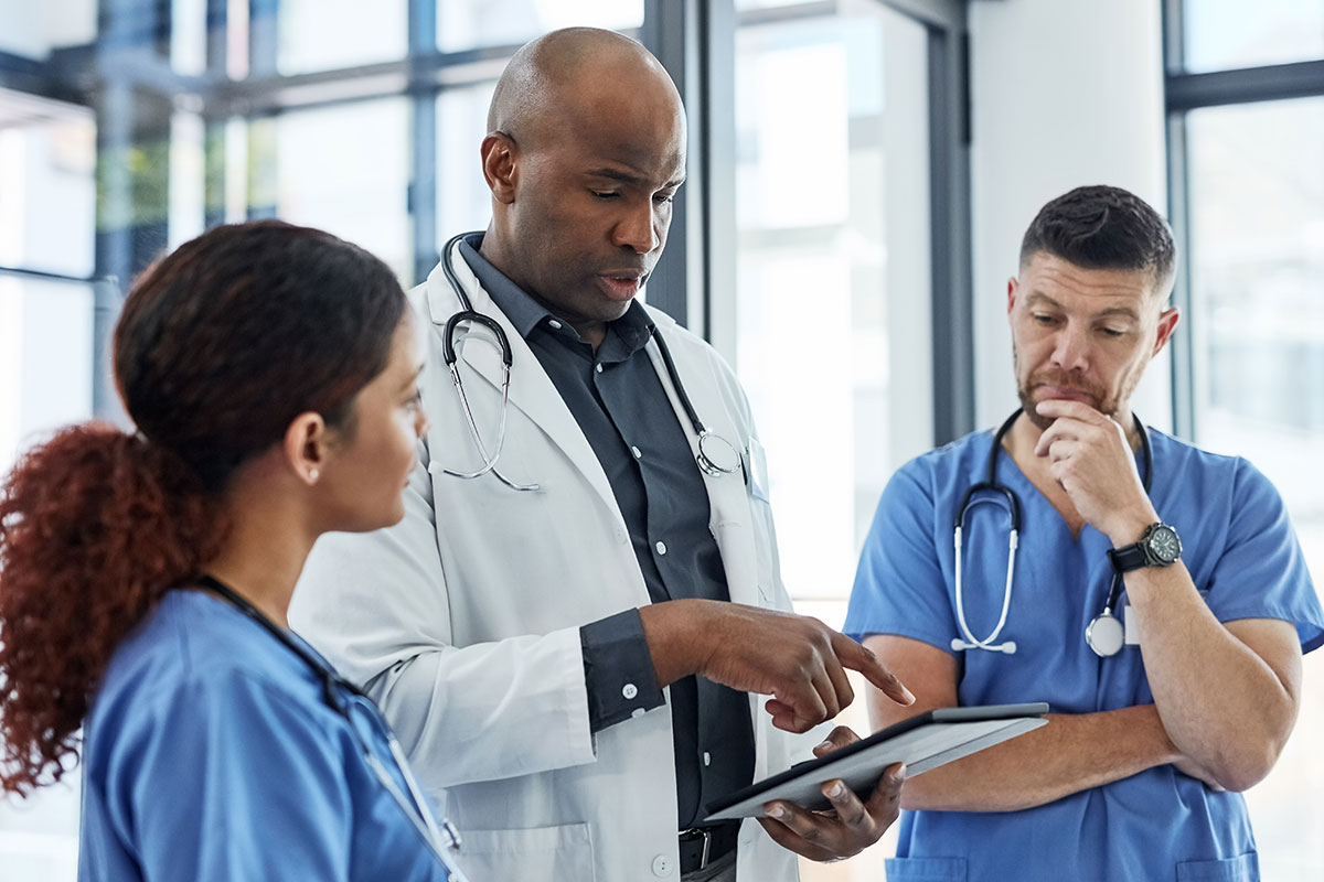 Doctor with tablet discussing procedure with staff